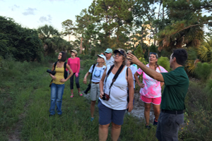 ERM staff discussing a point of interest to a group of participants on a guided hike through a natural area