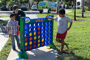 children and adult playing jumbo connect 4